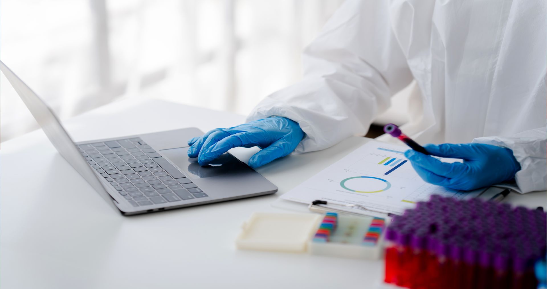 The image depicts a clinical or research laboratory environment where a scientist or medical laboratory technician is analyzing patient or sample data.